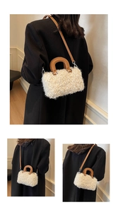Detail of white plush mini Boston bag featuring brown round handles and crossbody strap