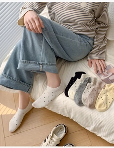 Polka dot cotton no-show socks in various colors worn comfortably on feet in a cozy setting