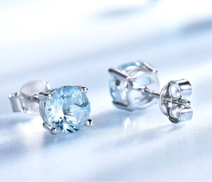 Vue macro de pierres précieuses bleues rondes sur boucles d'oreilles clous en argent