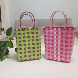 Detailed view of handmade woven bucket bags featuring colorful plaid patterns and handles