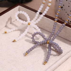Détail de colliers à nœuds perlés en blanc et violet avec facettes en cristal
