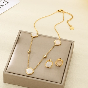 Golden stainless steel jewelry set with white shell clovers and sparkling crystals