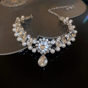 Macro shot of silver pearl and rhinestone waterdrop necklace with floral accents