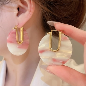 Gros plan de boucles d'oreilles en acétate plaqué or 18 carats au style rétro chic