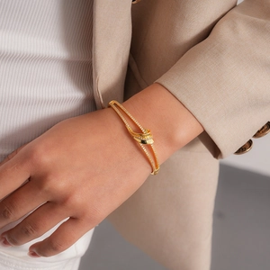 Detailed close-up of 18k gold plated double-layer bangle with sparkling zircon pavé knot