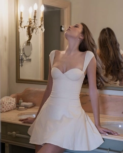 Detail of white off-the-shoulder mini dress with elegant A-line cut and slim fit design