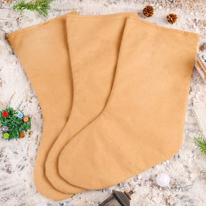 Three beige felt Christmas stockings with sequins on a festive wooden snowy background