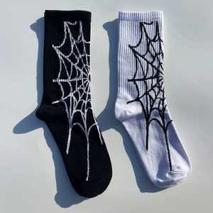Détail de motifs toile d'araignée sur chaussettes mi-mollet en coton noir et blanc
