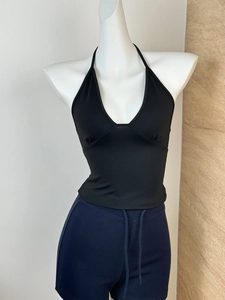 Close-up of black halter neck slim-fit top with deep V-neckline on mannequin display