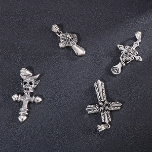 Macro view of four gothic silver pendants with cross, demon head, spider web and skull