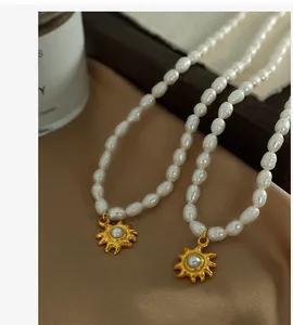 Macro shot of freshwater rice pearl necklace with a vintage gold sunburst pendant