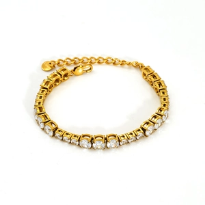 Macro detail of gold-plated tennis bracelet featuring round cubic zirconia and lobster clasp