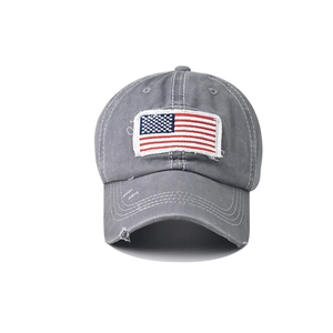 Detail of grey washed cotton baseball cap featuring vintage distressed holes and flag embroidery