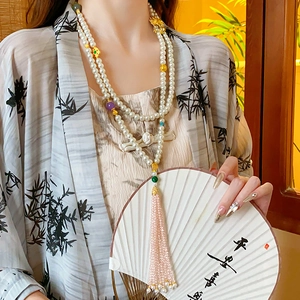 Macro detail of Chinese style double-row pearl necklace with bead fringe and tassels