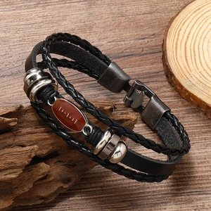 Macro detail of men's multilayer braided leather bracelet with vintage metal snap button