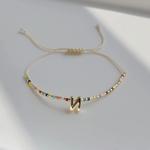 Nahaufnahme des verstellbaren Perlenarmbands mit goldenem Buchstaben N Anhänger