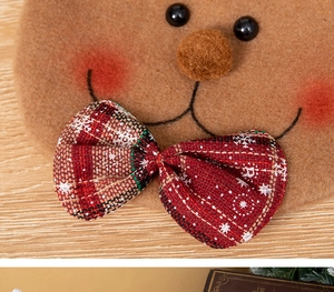 Macro detail of Christmas reindeer felt gift bag with snowflake pattern bow