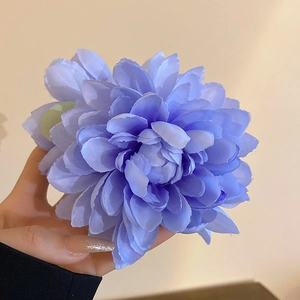 Detailed close-up of blue fabric lotus hair clip showing petal texture and size