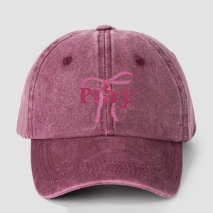 Macro detail of wine red washed cotton baseball cap with pink Pray and bow print