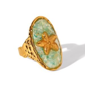 Close-up of golden starfish ring with blue crushed shell inlay and hammered metal texture