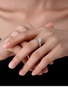 Macro detail of a 1 carat round moissanite ring with side stones on a S925 silver band