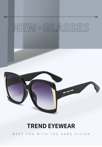 Detail of square sunglasses with gold metal accents on black frames and purple gradient lenses