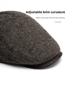 Detail of widening leather brim on herringbone flat cap showing foldable feature