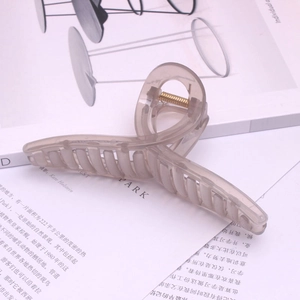 Detailed view of large transparent grey claw clip with a strong golden spring accessory