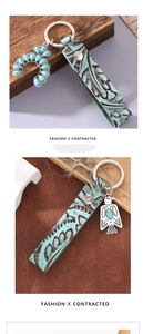 Detail of vintage turquoise leather keychain with eagle and horseshoe metal pendants