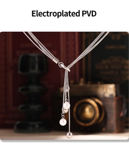 Detailed macro of silver multilayer chain necklace with pearl pendants and PVD plating