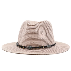 Detailed view of straw fedora with black leather cord and turquoise stone accents