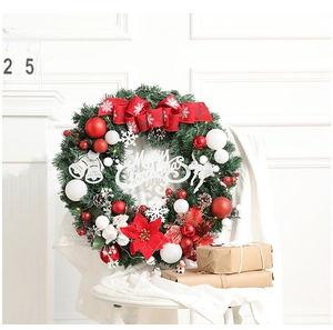Détail d'une couronne de Noël avec nœud rouge, pommes de pin et signe Merry Christmas