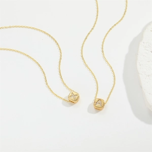 Delicate gold square alphabet pendant necklace featuring zircon studs and minimalist design