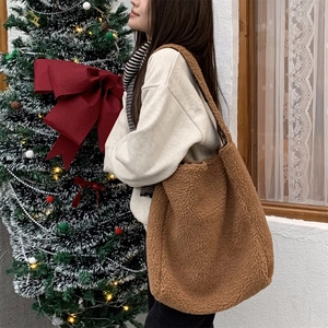 Detailed texture of brown teddy fleece shoulder bag with a cozy winter festive background