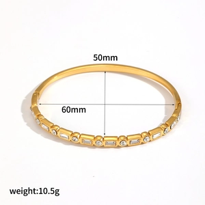 Detail view of 18K gold plated bangle with dimensions 60mm by 50mm and crystal inlays