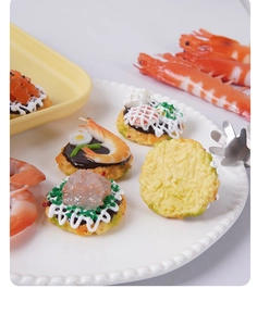 Dettaglio di modelli alimentari realistici con torte di gamberi e base a nido d'ape