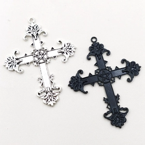 Detail of gothic silver and black cross pendants with engraved star patterns