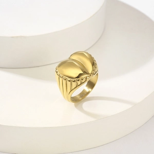 Retro 18K gold plated heart ring with vertical stripe texture on a white display stand
