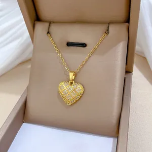 Macro del ciondolo a cuore in oro 18K con trama a griglia e cristalli in astuccio beige
