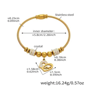 Détail du bracelet en acier inoxydable doré avec design torsadé et pendentif cœur d'amour