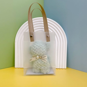 Detail of transparent PVC gift bag with teddy bear and pearl ribbon decoration