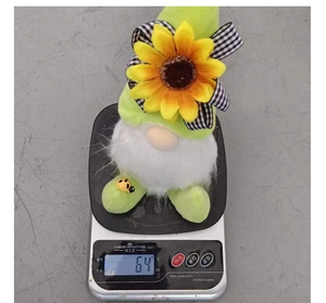 Dettaglio che mostra lo gnomo di peluche girasole da 64g su una bilancia digitale