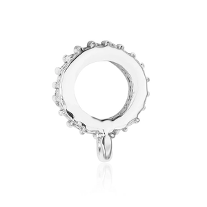 Macro shot of silver circular pendant base with hollow center and jagged edges detail