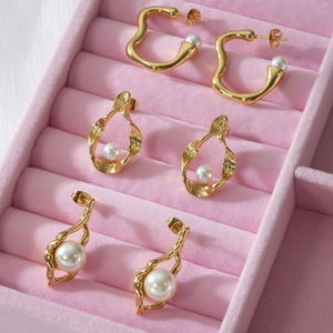 Drei Paar elegante 18k vergoldete unregelmäßige Edelstahl-Perlenohrringe auf rosa Samt
