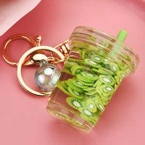 Detail of creative kiwi fruit tea liquid keychain with floating glitters and gold clasp
