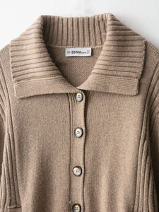 Detail of camel chunky knit cardigan featuring oversized lapels and tortoiseshell buttons