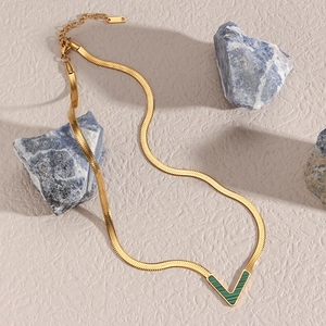 V-shaped gold necklace with green malachite inlay on a sleek stainless steel snake chain