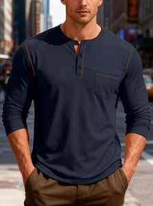 Detail of navy blue long sleeve henley shirt with orange stitching and chest pocket