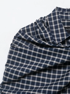 Detailed view of dark blue and white plaid shirt collar and shoulder seam craftsmanship