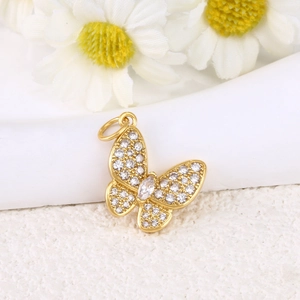 Detailed close-up of a gold butterfly pendant with sparkling white zircons and daisies